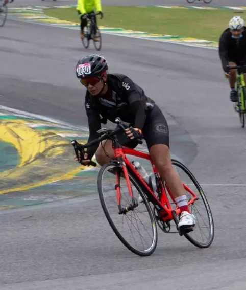 Denise pedalando de bicicleta em uma prova de ciclismo