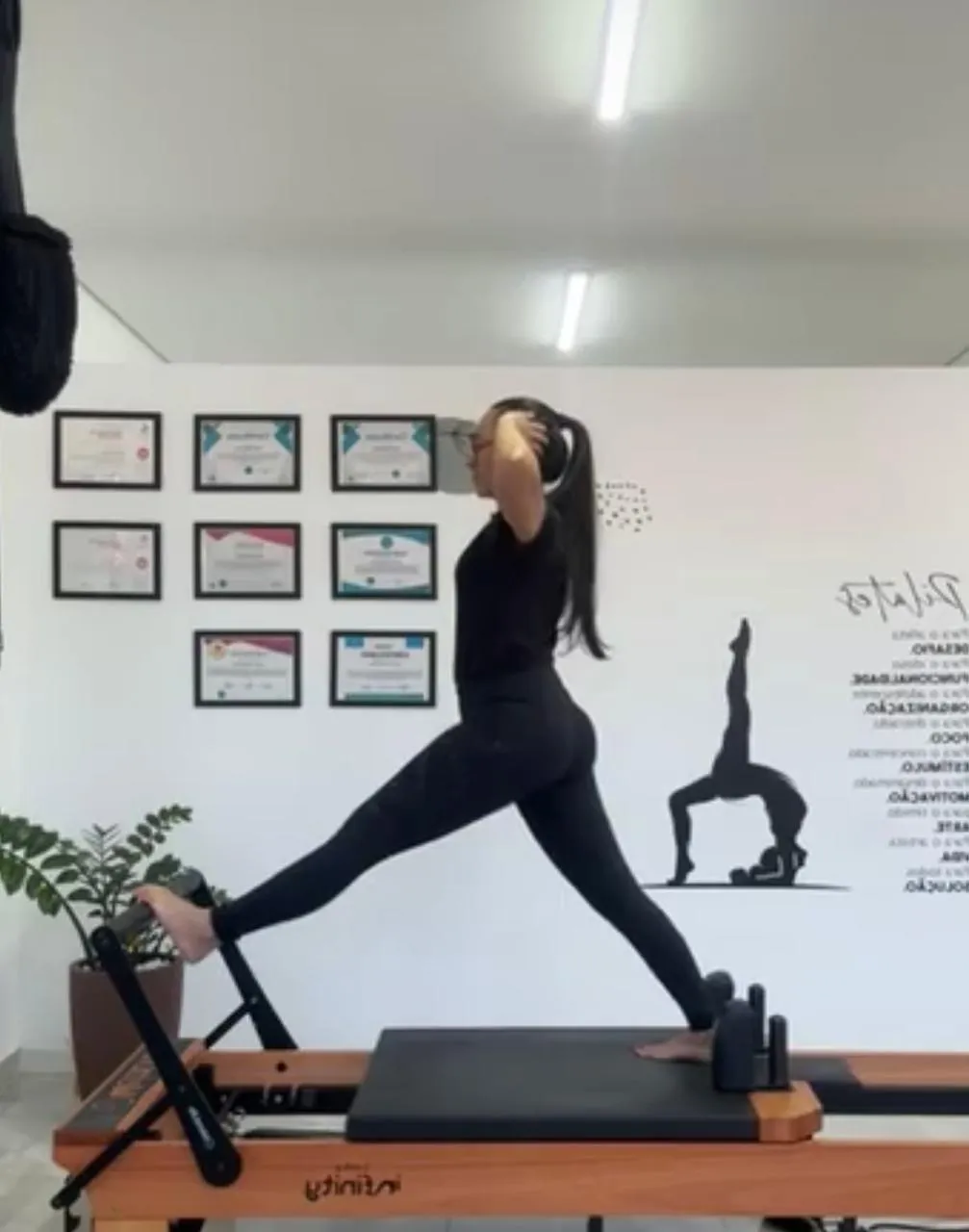 Denise fazendo um exercício no reformer do estúdio